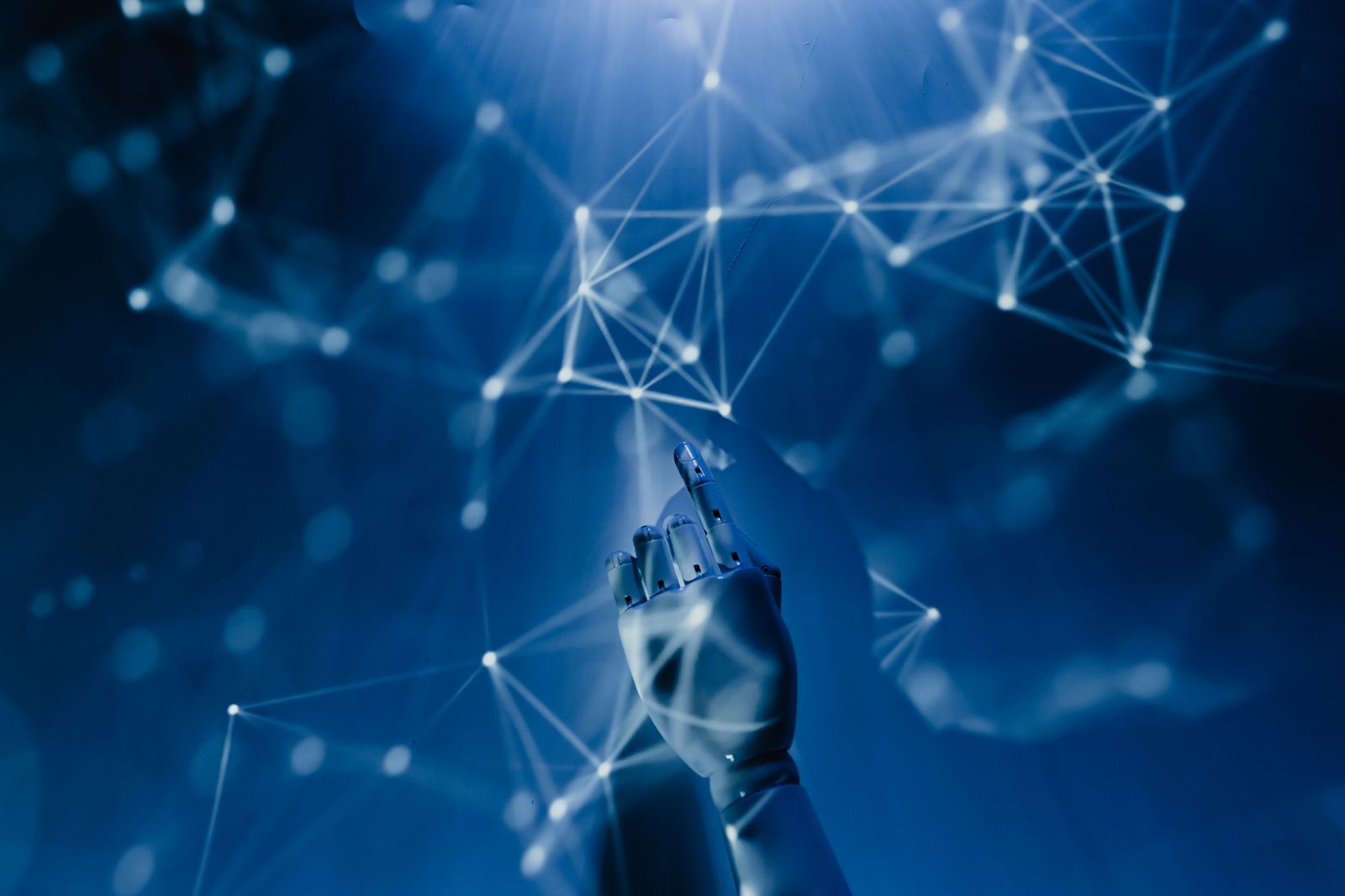 A robotic hand reaching into a glowing network of connected points, symbolising AI working alongside people