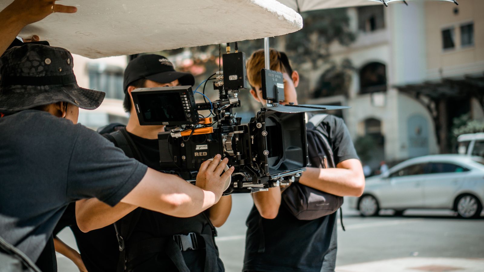 A film crew operating a cinema camera on location, the traditional videographer model in action